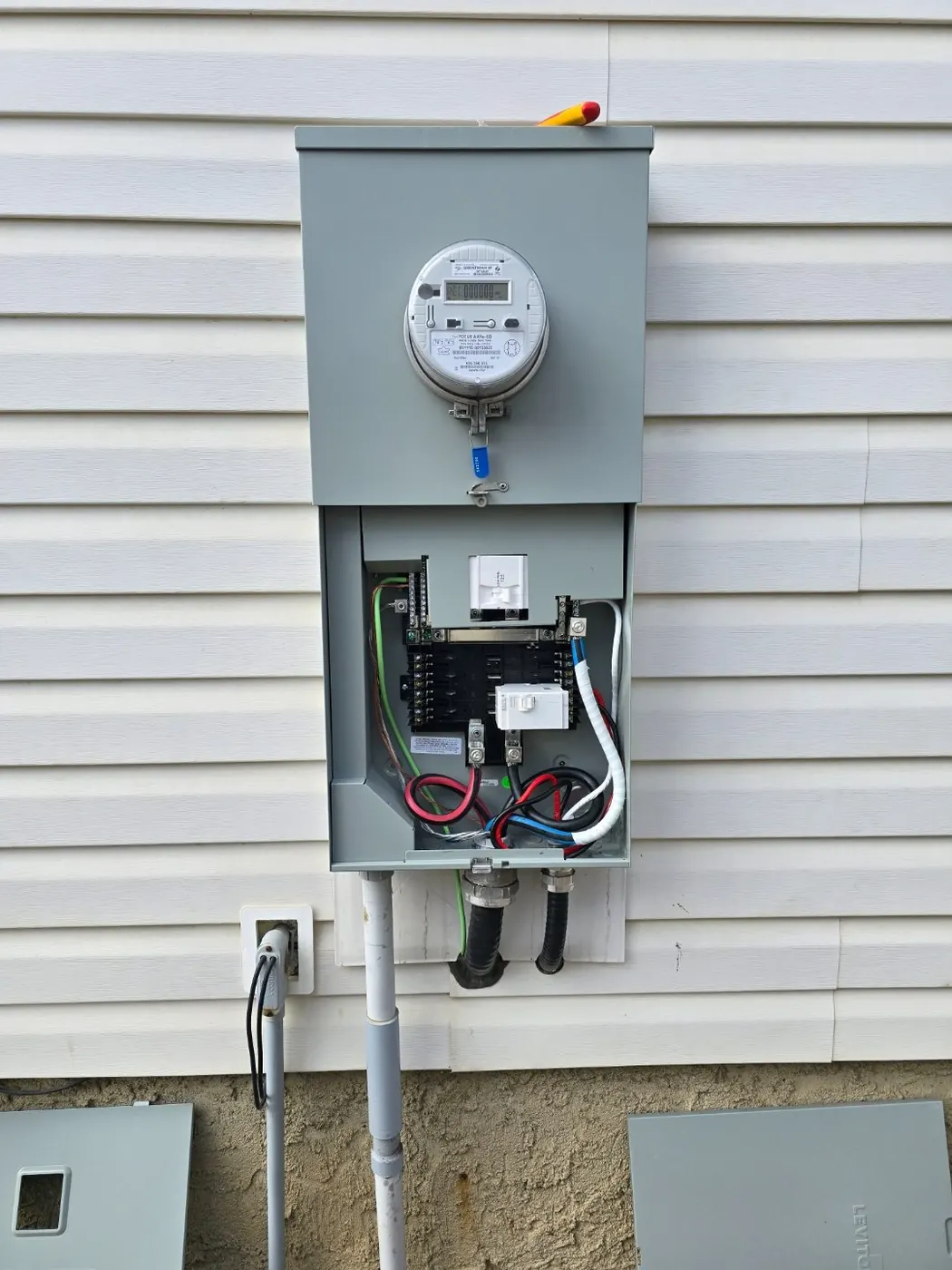 An outdoor meter base and exterior disconnect on the wall of an Edmonton home, where a transfer switch gets mounted