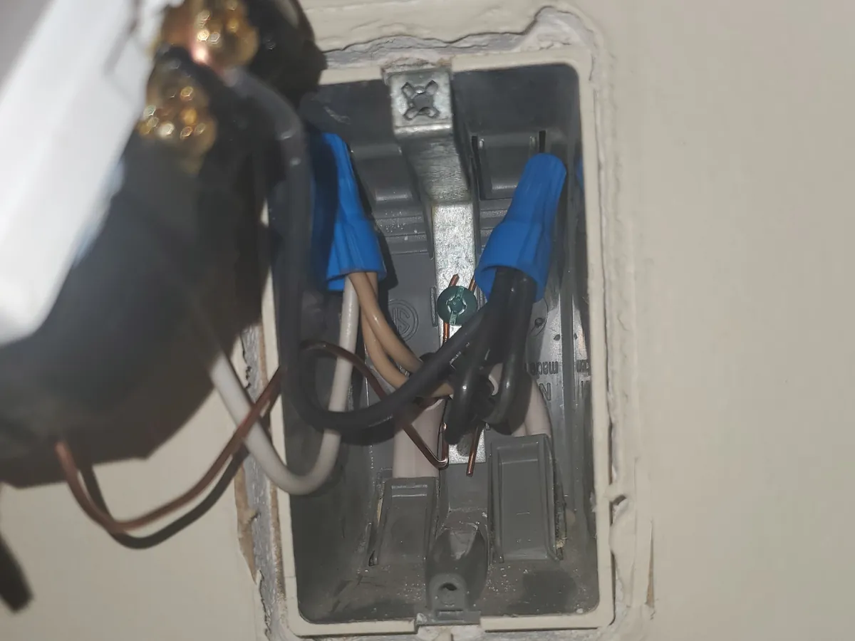 The same box redone, the wires joined with connectors and short leads wrapped around the screws of the new outlet