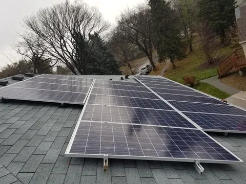 The same grey shingle roof with the solar panels mounted on the rails