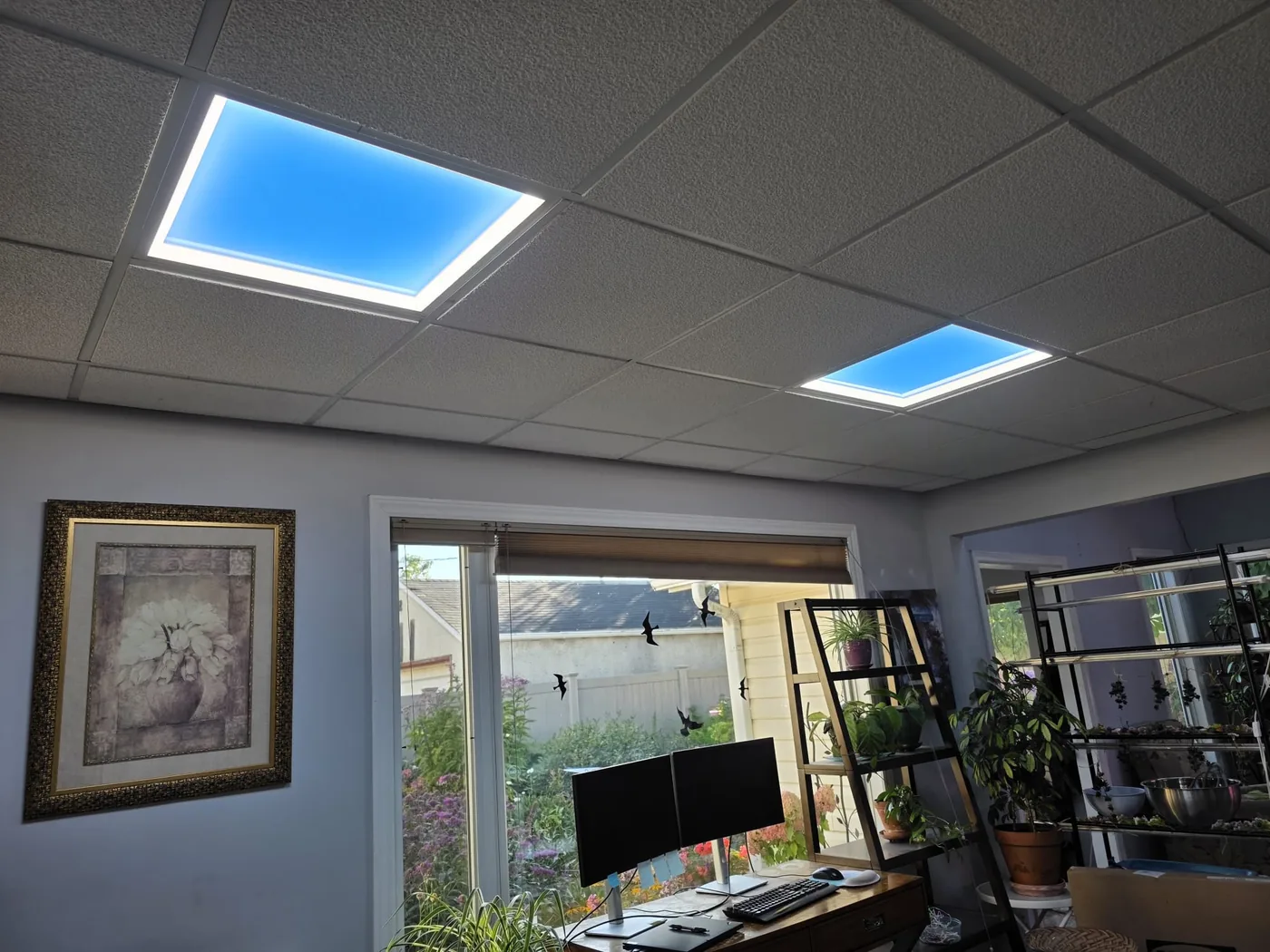 Upstairs office ceiling with two LED skylight panels showing blue sky