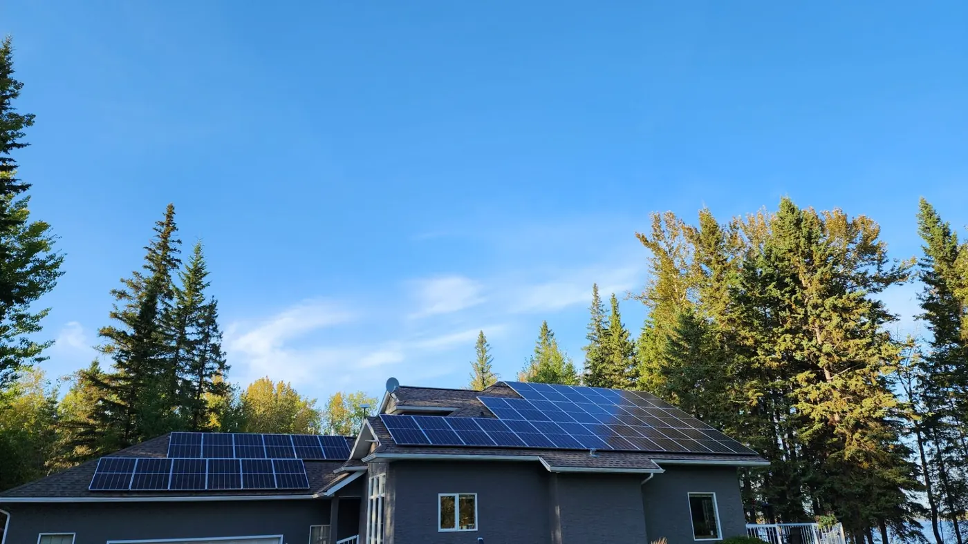 Completed all-black rooftop solar array on a residential home in autumn, installed by Raydn Renewables in Alberta