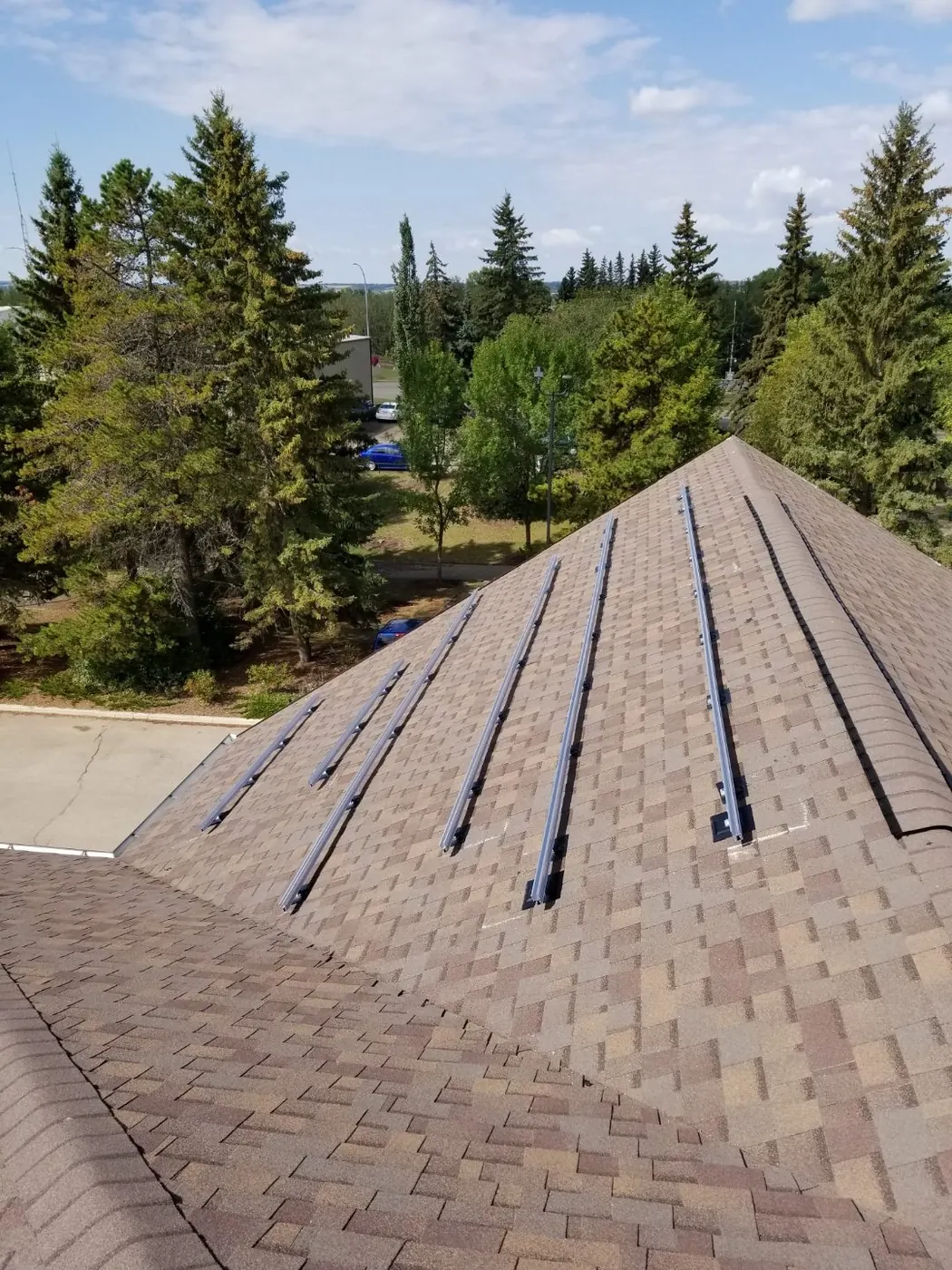 Solar mounting rails on brown shingle roof before panels Alberta