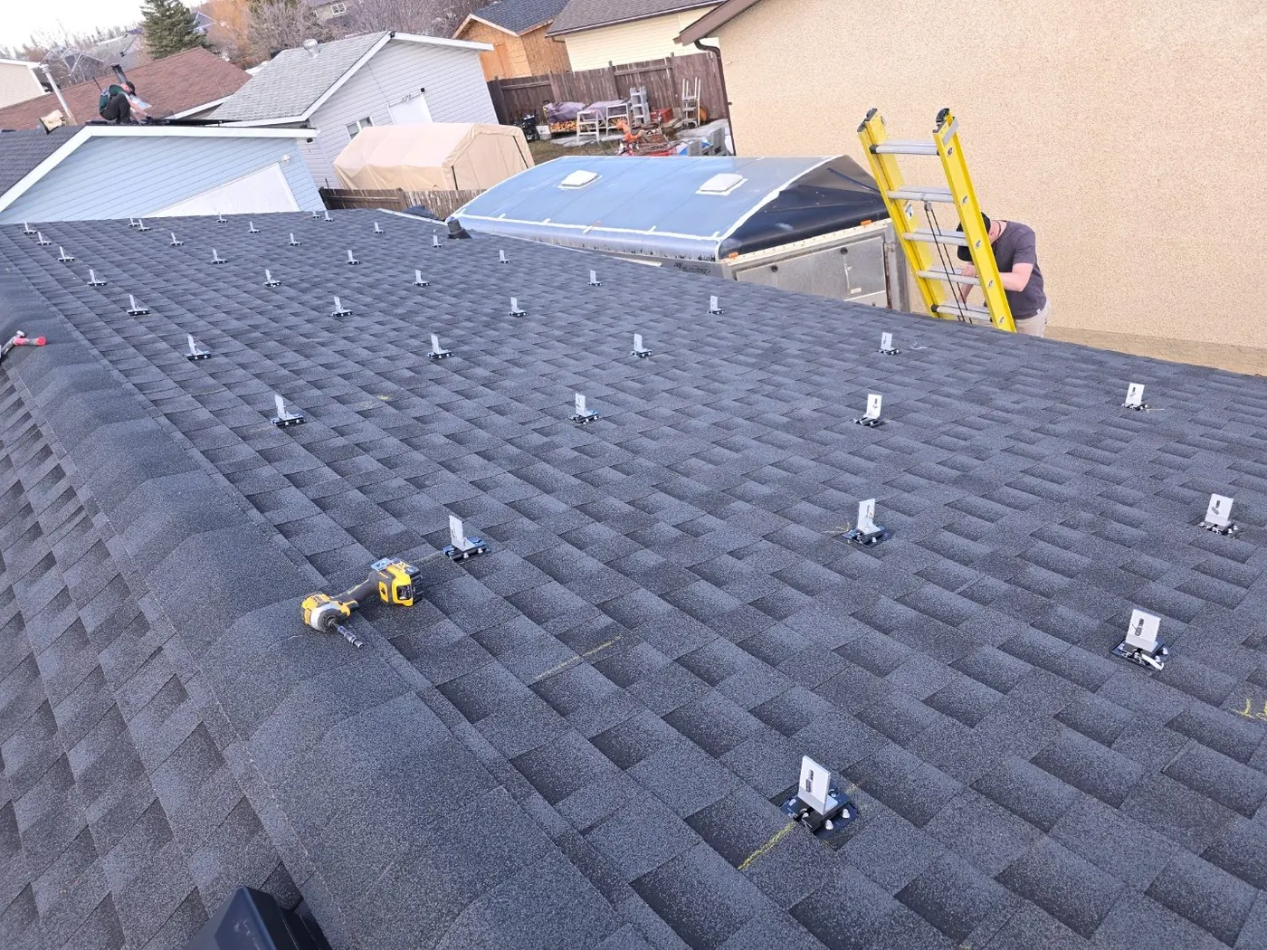 Dark grey shingle roof with solar mounting standoffs before panels, Edmonton