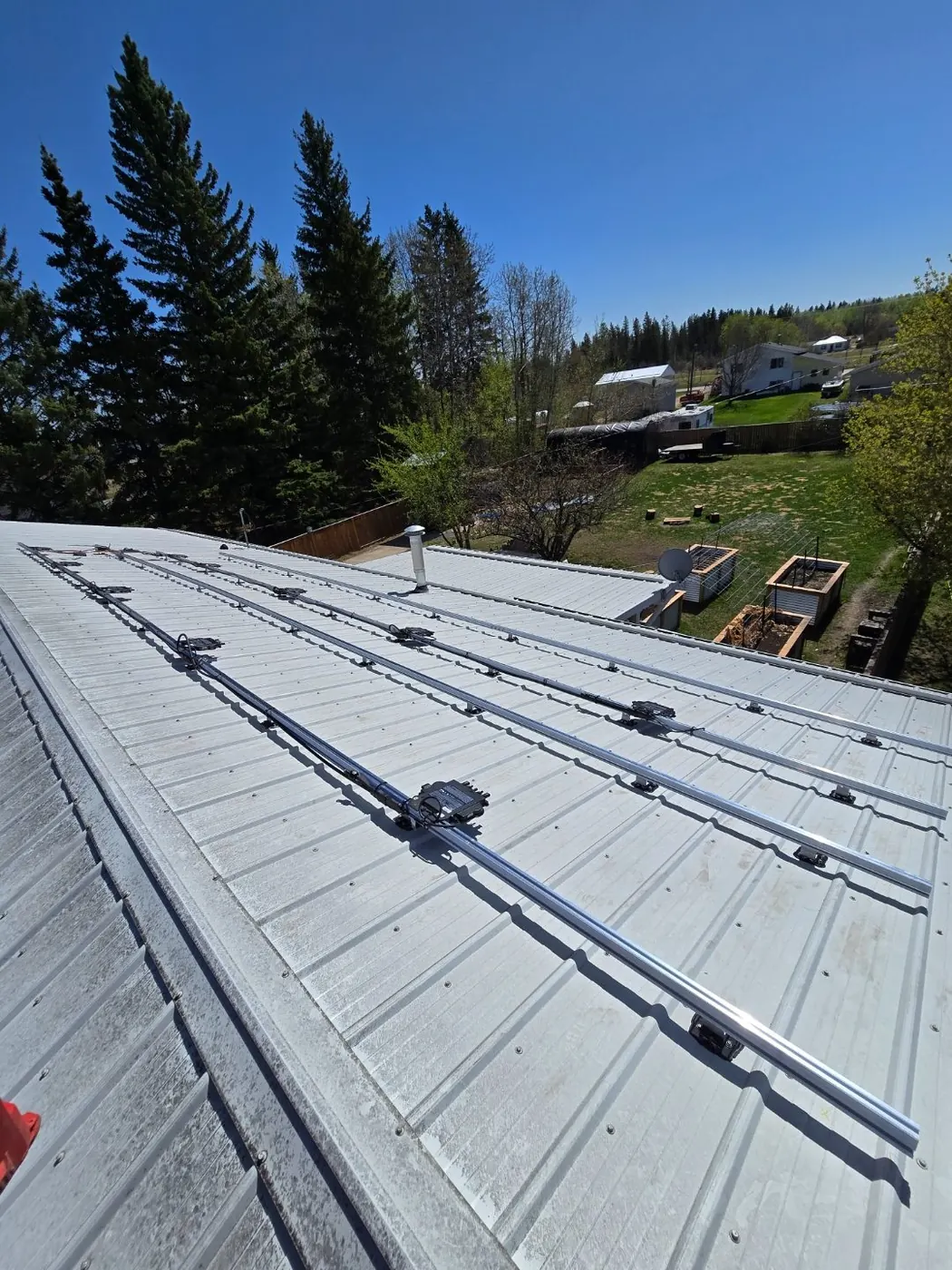 Before: silver galvanized metal roof with solar mounting rails, rural Alberta