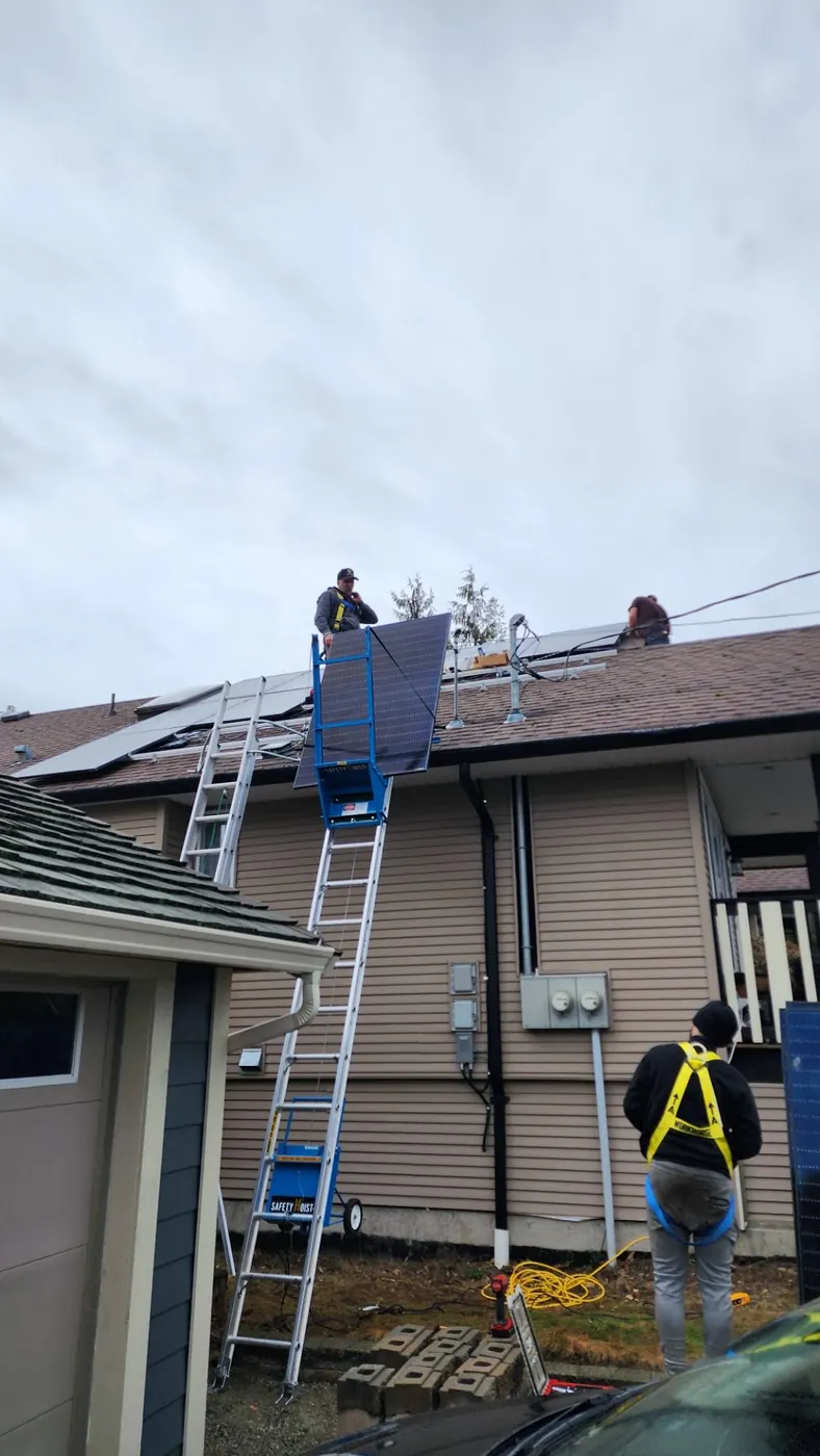 Raydn crew hoisting solar panels onto residential roof in Alberta