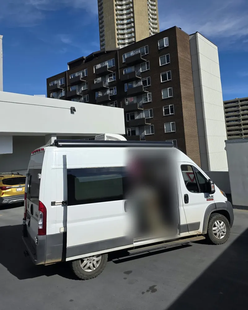 White camper van parked in a lot with its side door open